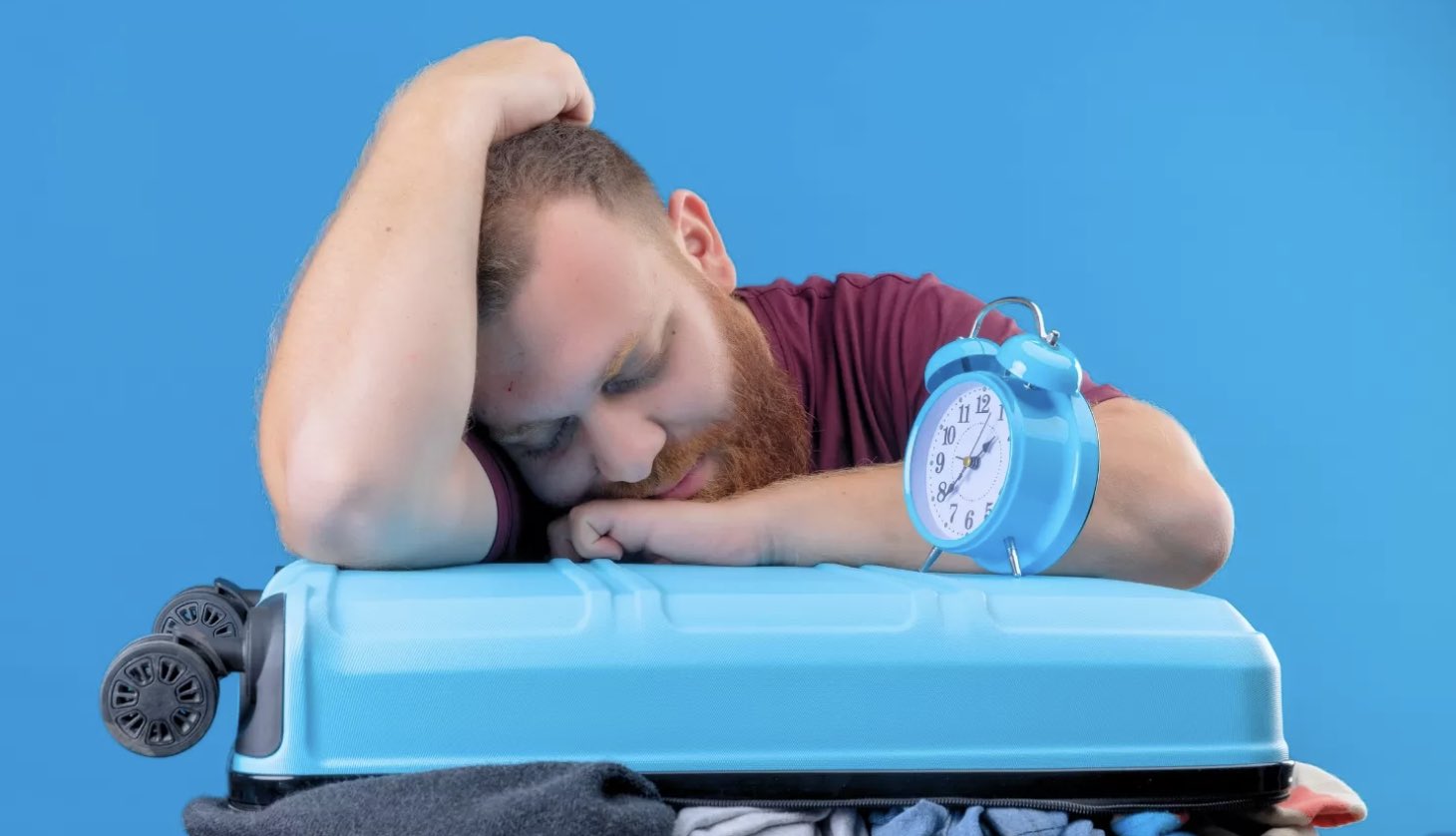 man sleeping on luggage